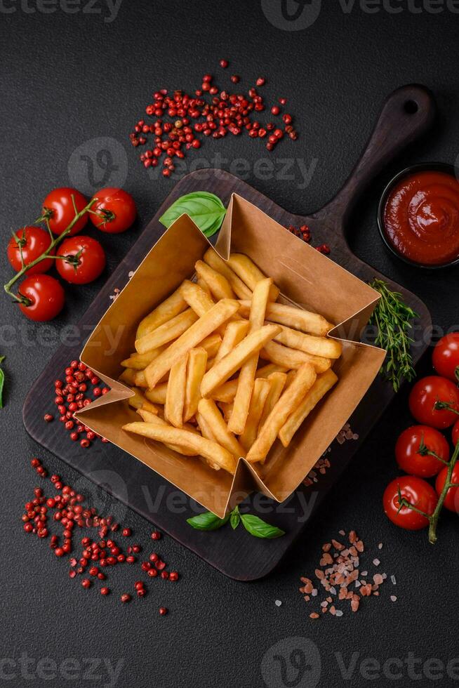 Delicious crispy french fries with salt and spices in a cardboard box photo