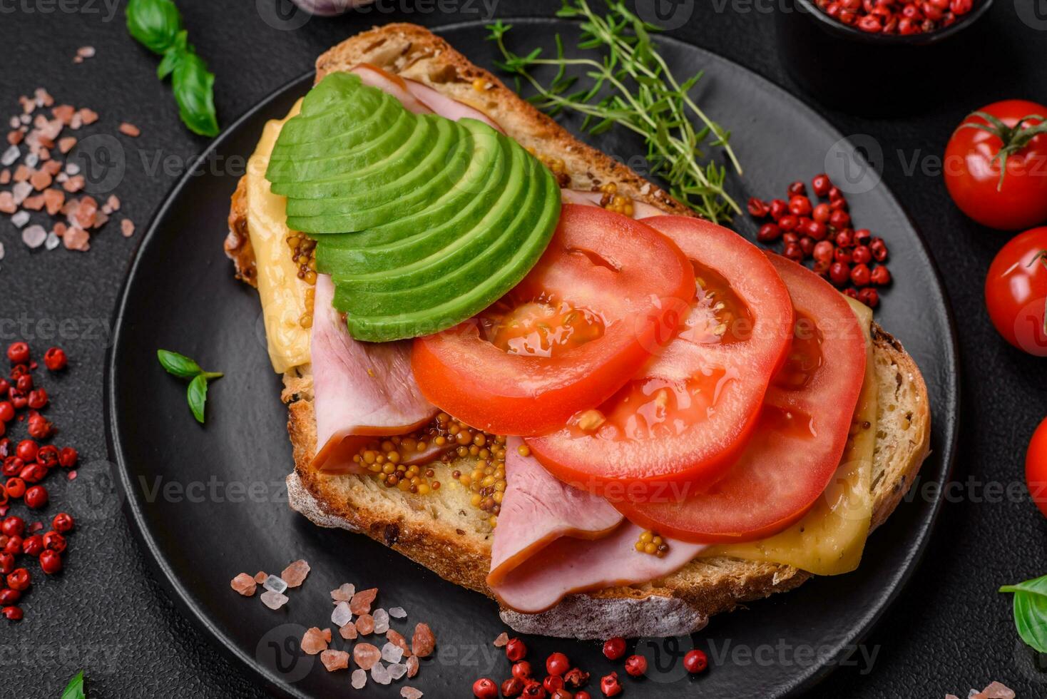 delicioso nutritivo A la parrilla brindis con jamón, queso, Tomates y aguacate foto