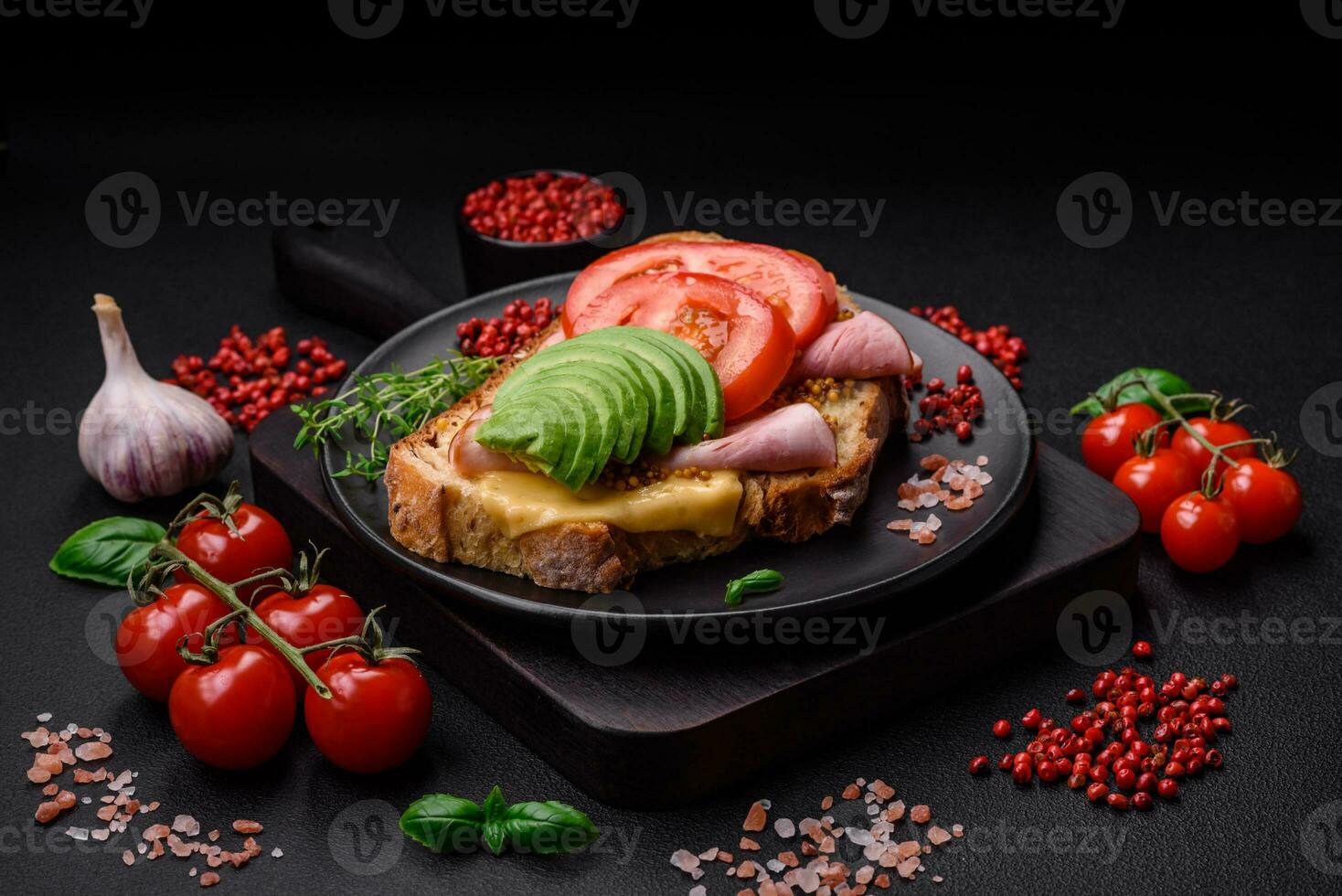 Delicious nutritious grilled toast with ham, cheese, tomatoes and avocado photo