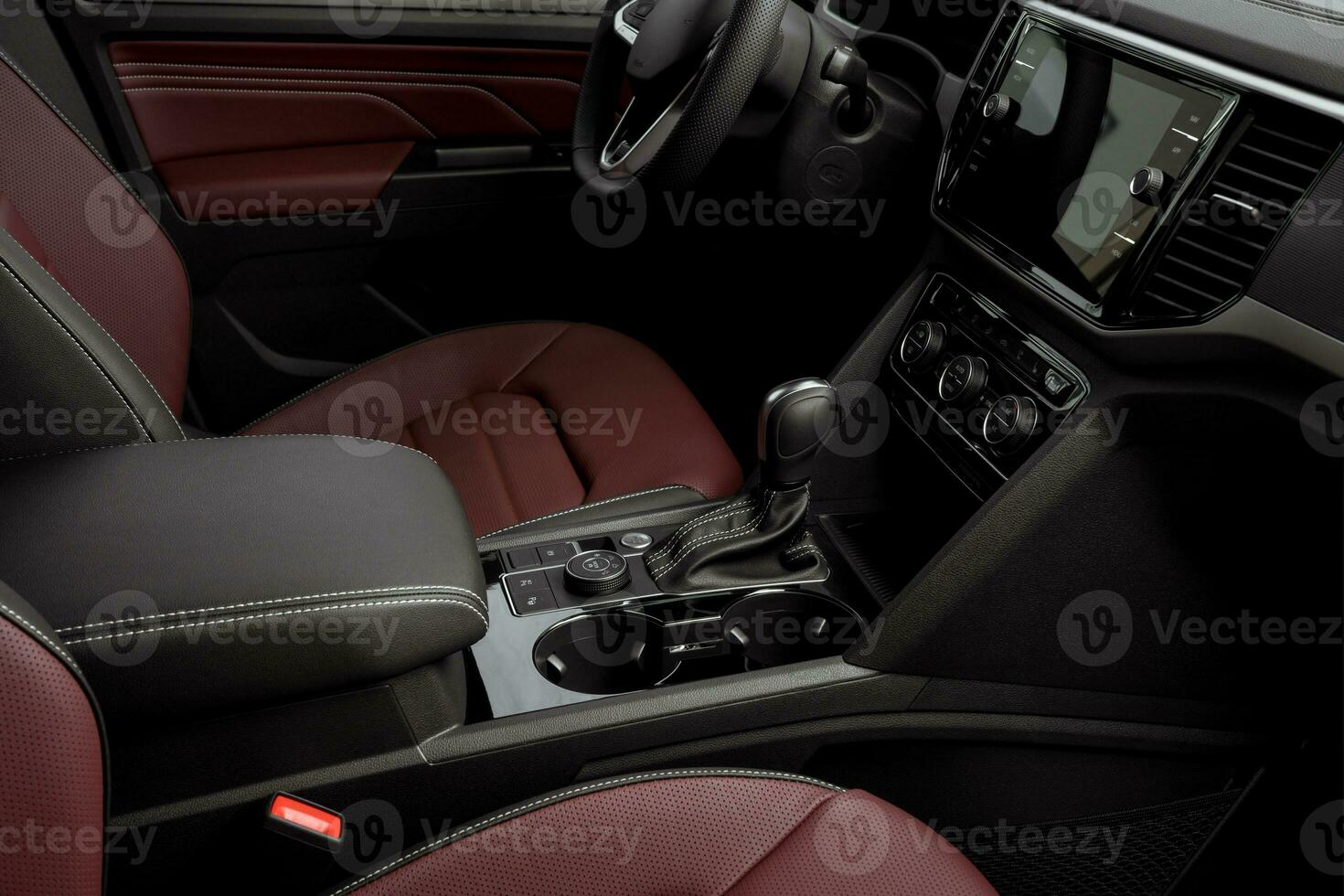 side view of the interior of a luxurious car dashboard, red leather seats, automatic transmission, steering wheel and touch screen photo