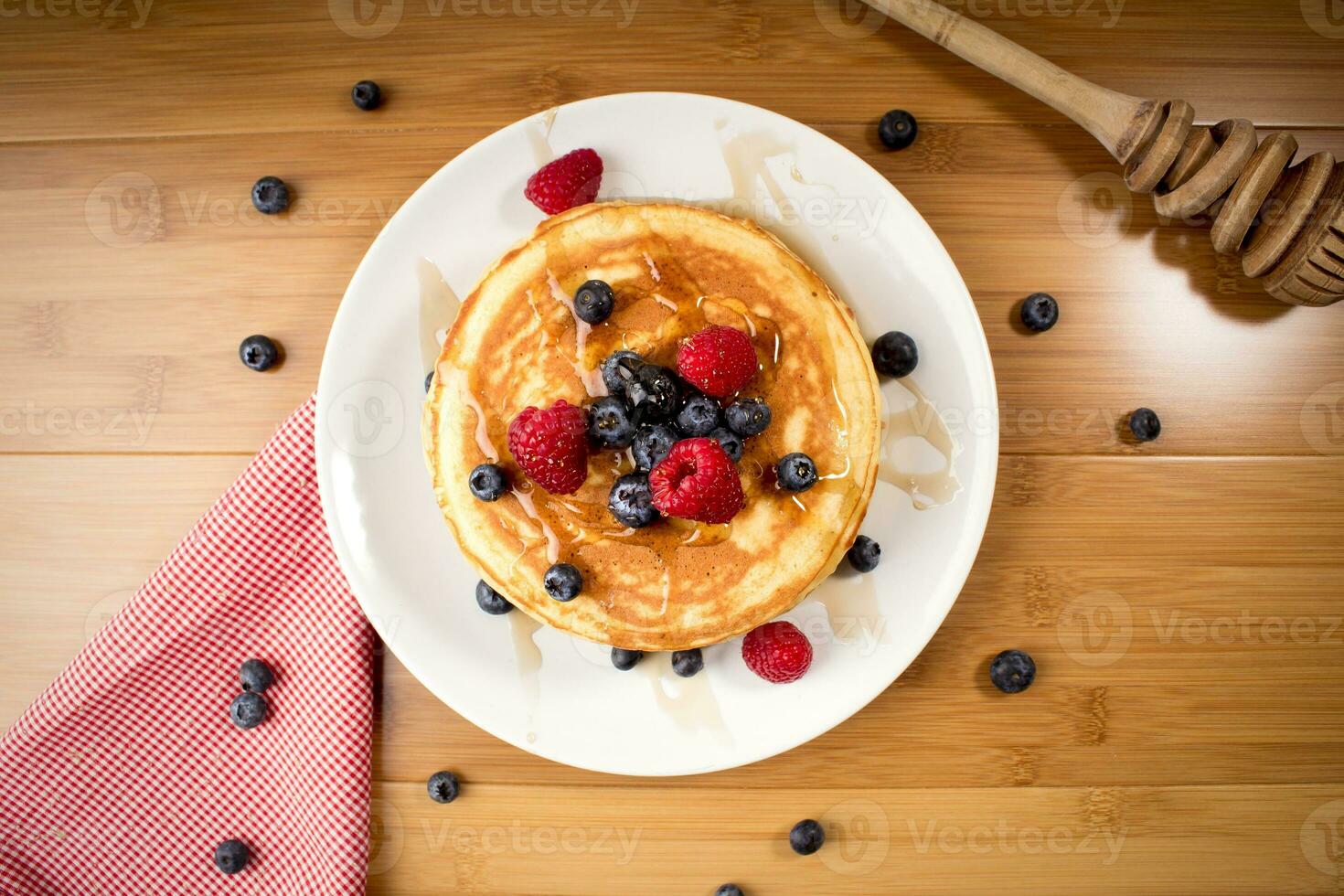 American pancakes with blueberries and raspberry, over wooden surface photo