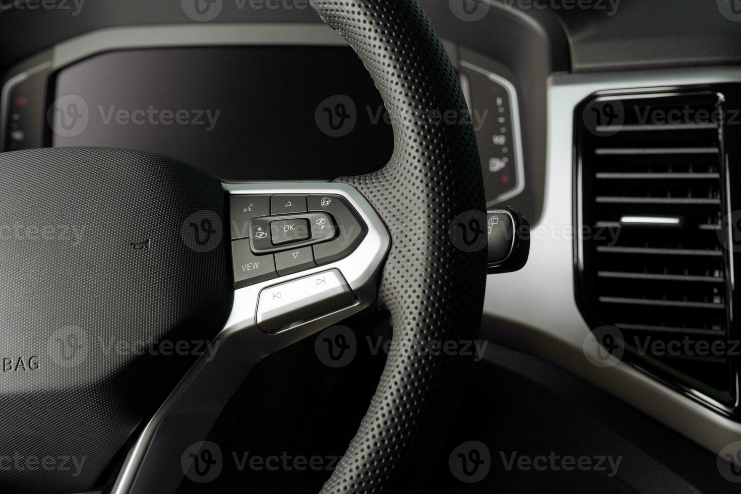 Steering wheel of a new vehicle close up, interior cockpit, electric buttons, digital speedometer photo