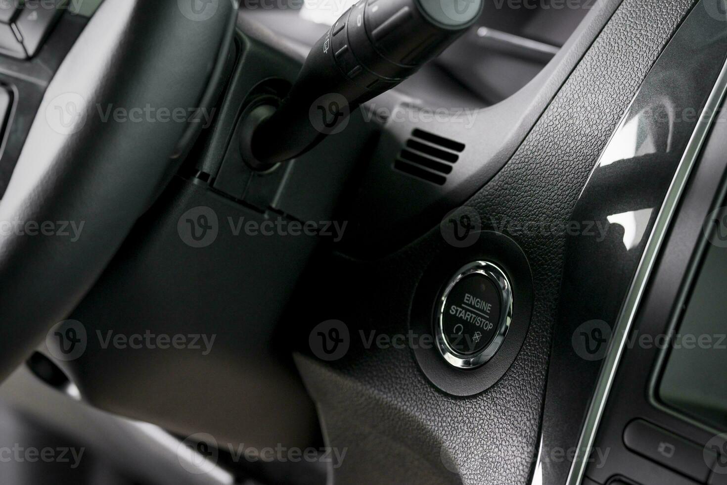 close up start stop button and windscreen wiper switch inside a new car photo