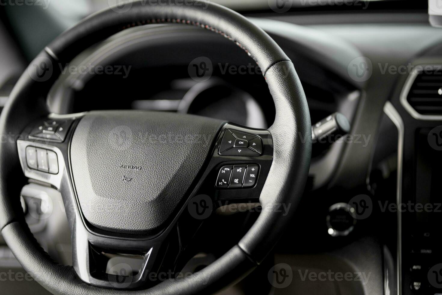 Steering wheel close up inside a new car, airbag, cruise control, wiper switch and a modern dashboard photo