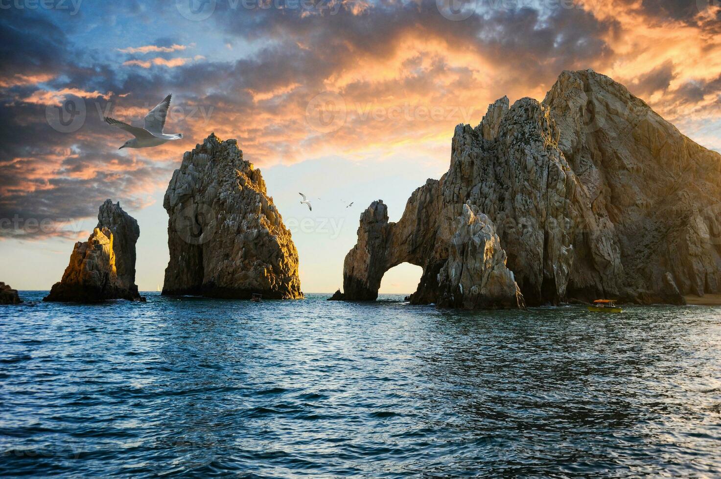 Seagulls flying above the distinctive arch of Cabo San Lucas, a formation of rocks on the peninsula's southernmost tip at Cabo San Lucas, Baja California, Mexico. photo