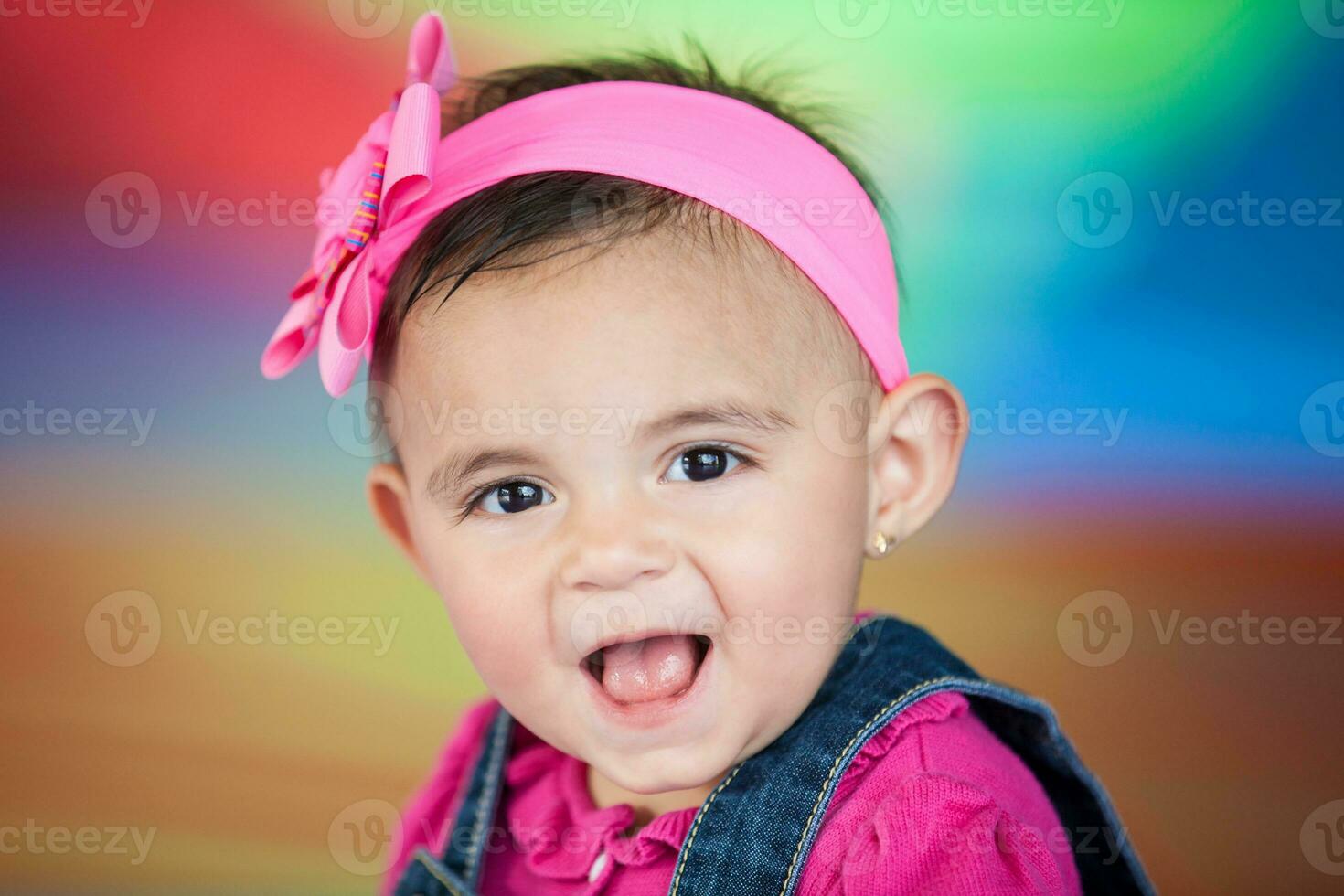 Portrait of a happy beautiful ten months baby girl on a colorful background. Early stimulation for toddlers concept. photo