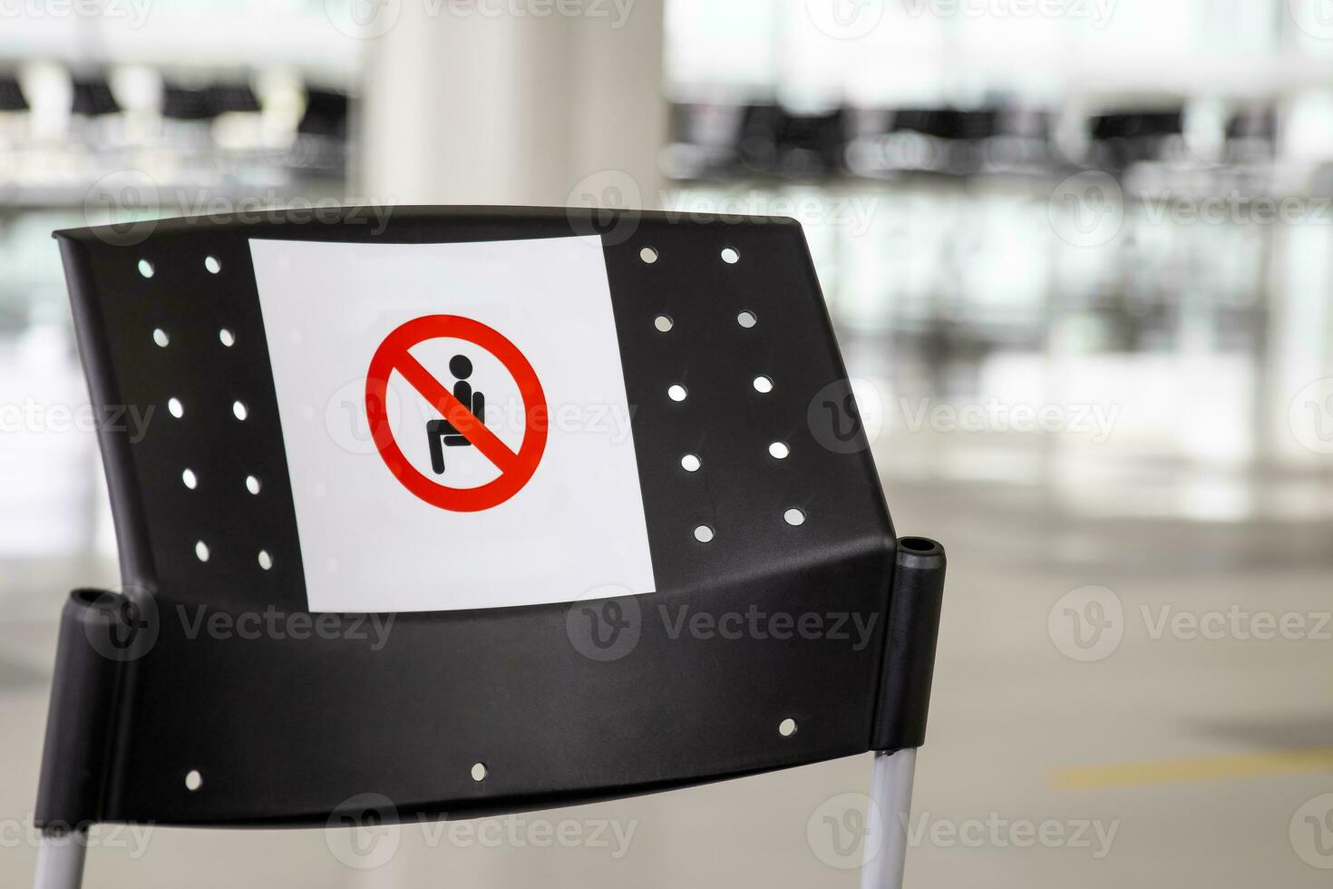 Empty wating room at an airport during COVID 19 pandemic with social distancing signs on chairs photo