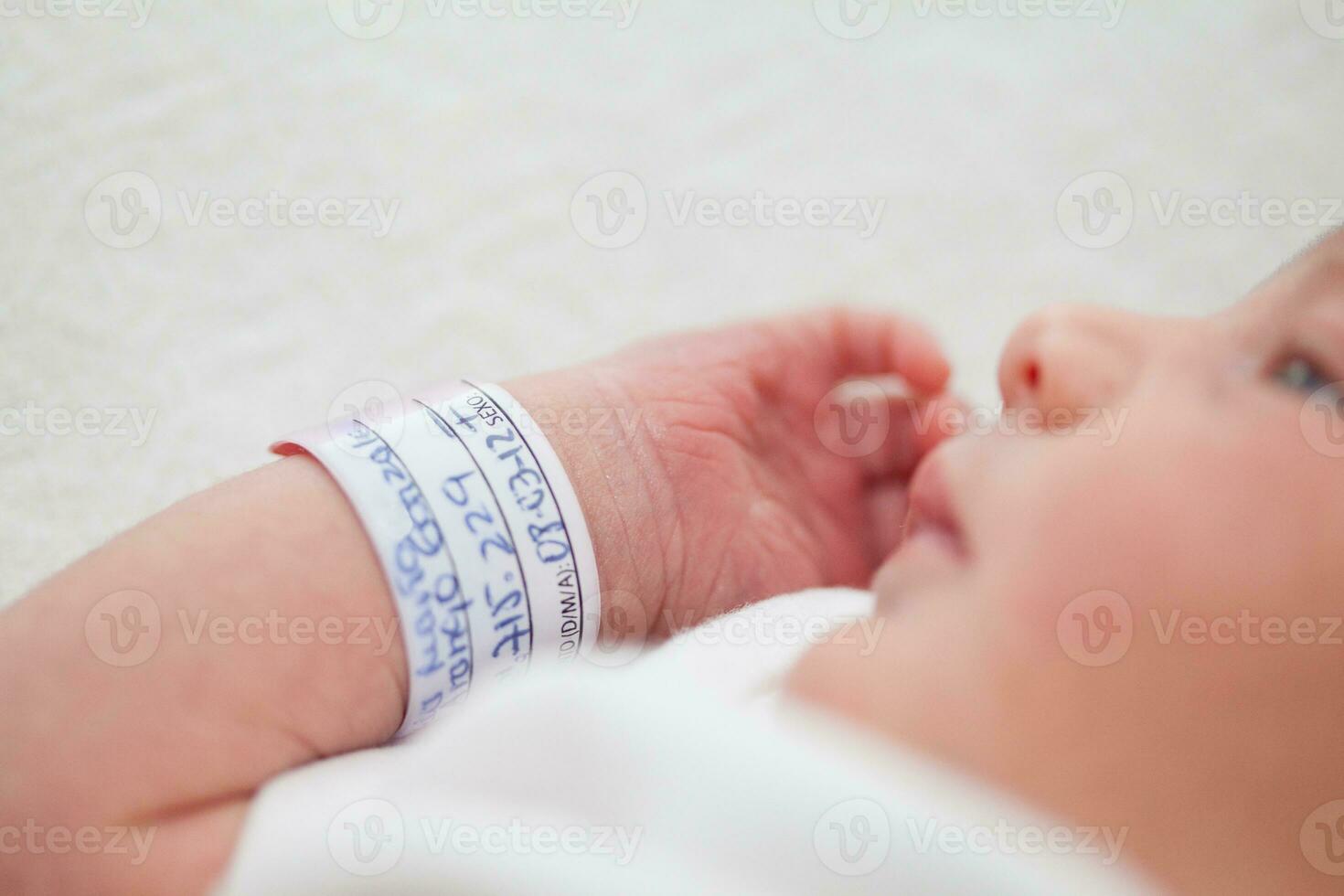 Closeup of a newborn arm and bracelet at hospital on the day of her birth photo