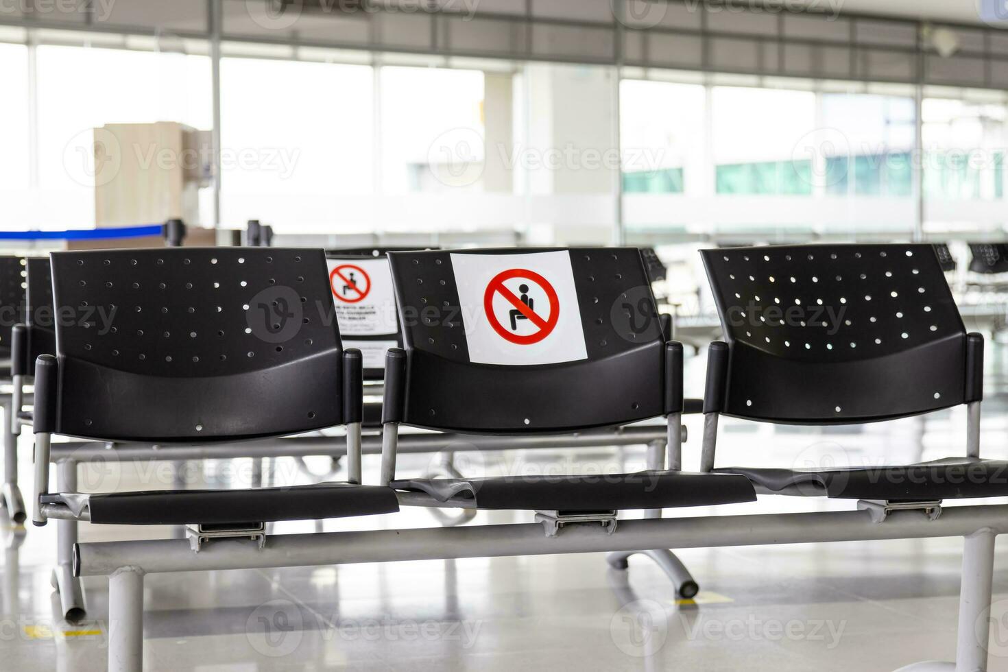 Empty wating room at an airport during COVID 19 pandemic with social distancing signs on chairs photo