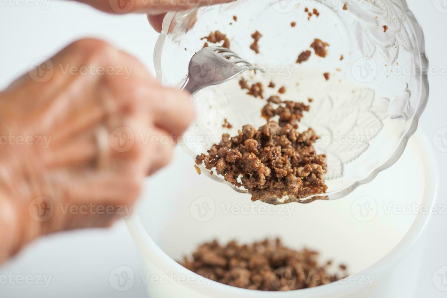 Step by step Levantine cuisine kibbeh preparation. Mixing the ingredients to prepare kibbeh filling into a bowl photo