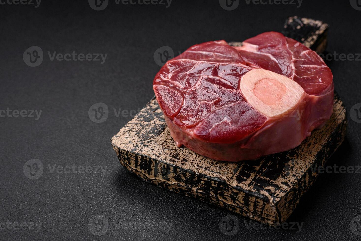 Fresh raw beef steak with bone or ossobuco with salt, spices and herbs photo