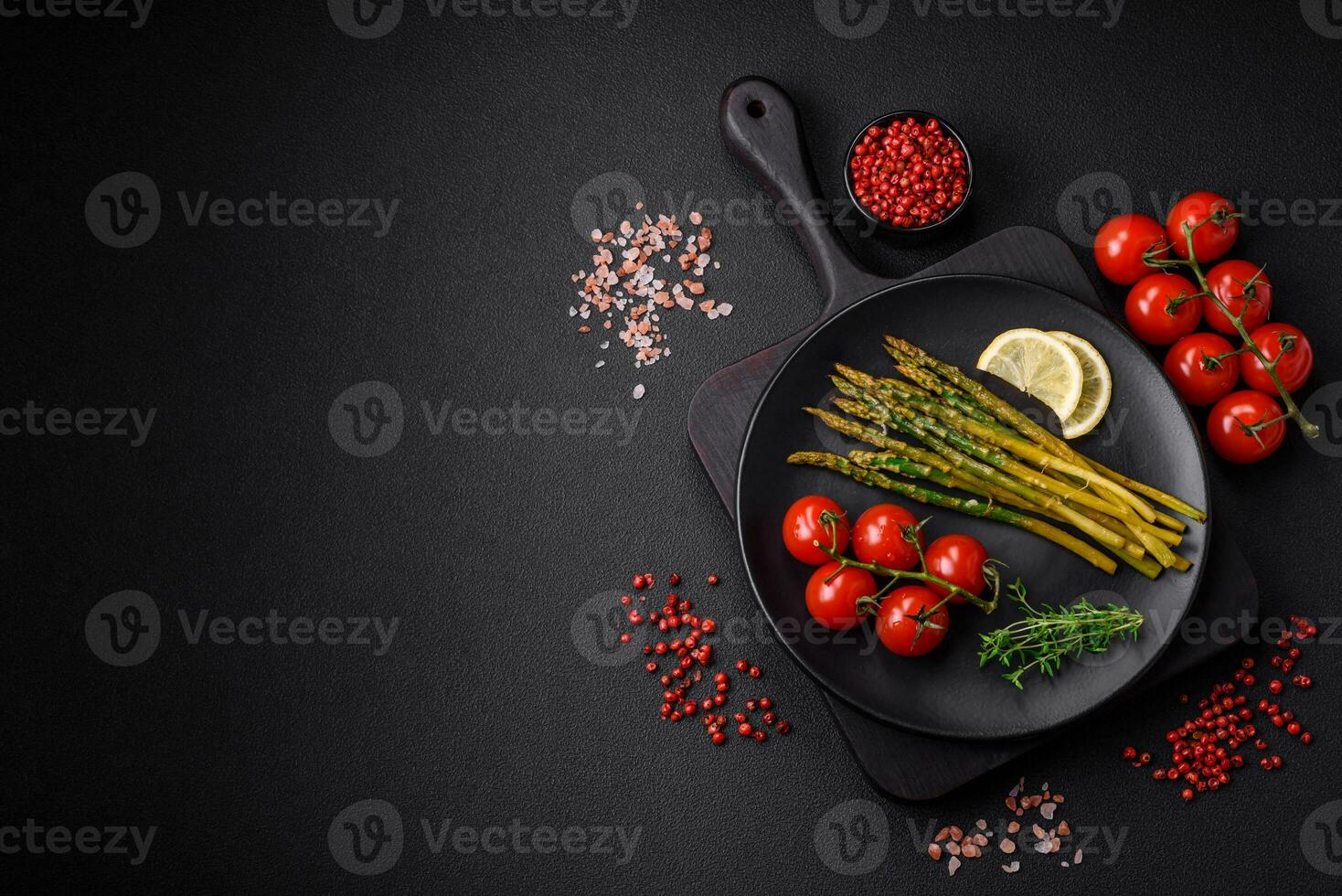 Delicious nutritious breakfast consisting of asparagus, tomatoes, salt, spices and herbs photo