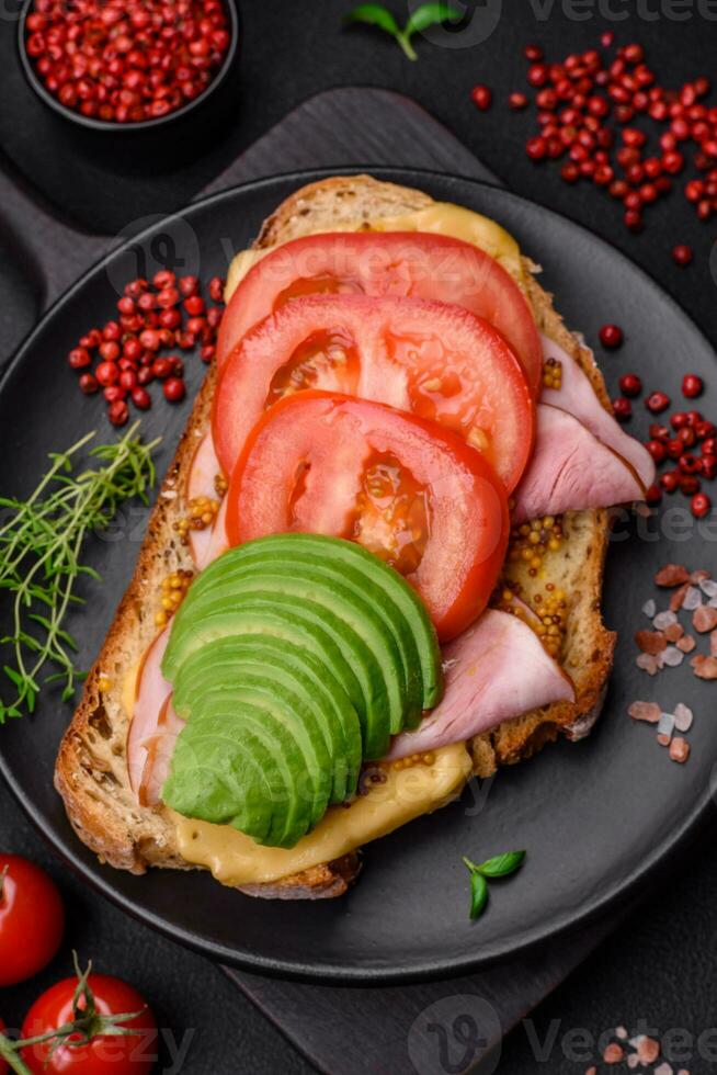 delicioso nutritivo A la parrilla brindis con jamón, queso, Tomates y aguacate foto