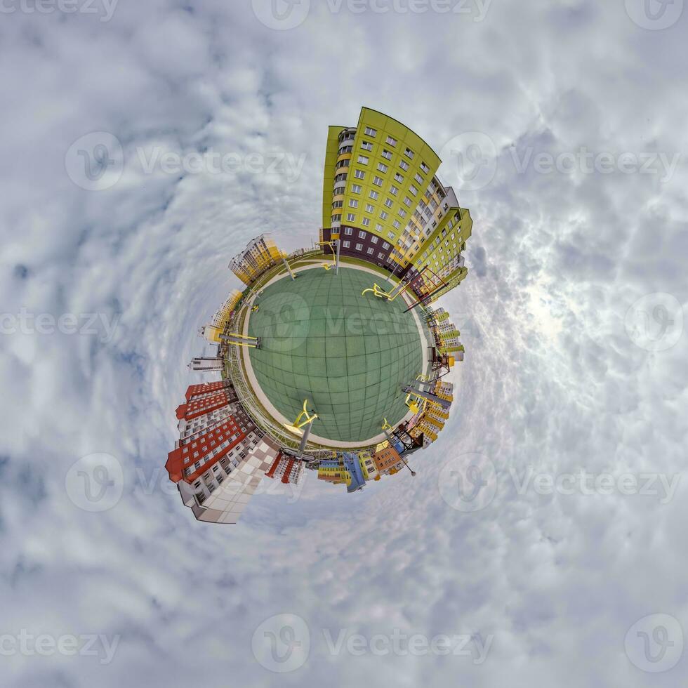 tiny planet in blue sky with clouds in city center near modern skyscrapers in residential complex. Transformation of spherical 360 panorama in abstract aerial view. photo