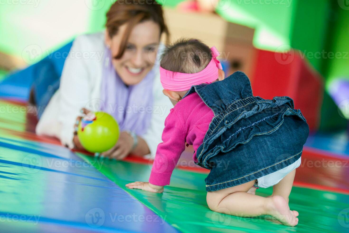 Beautiful ten months baby girl playing with her mom. Early stimulation for toddlers concept. photo