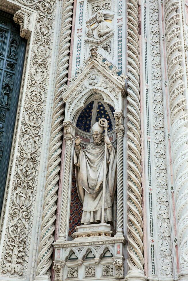 Statue on the facade of the beautiful Florence Cathedral formally called Cattedrale di Santa Maria del Fiore consecrated in 1436 photo