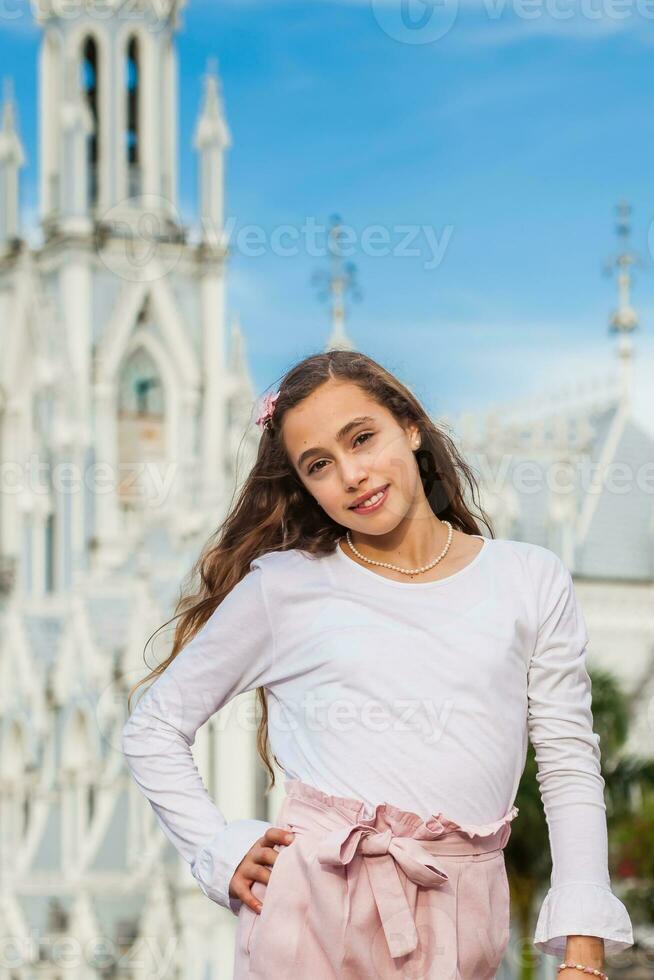 hermosa joven niña a el río bulevar en frente de el famoso gótico Iglesia de la ermita construido en 1602 en el ciudad de cali en Colombia foto