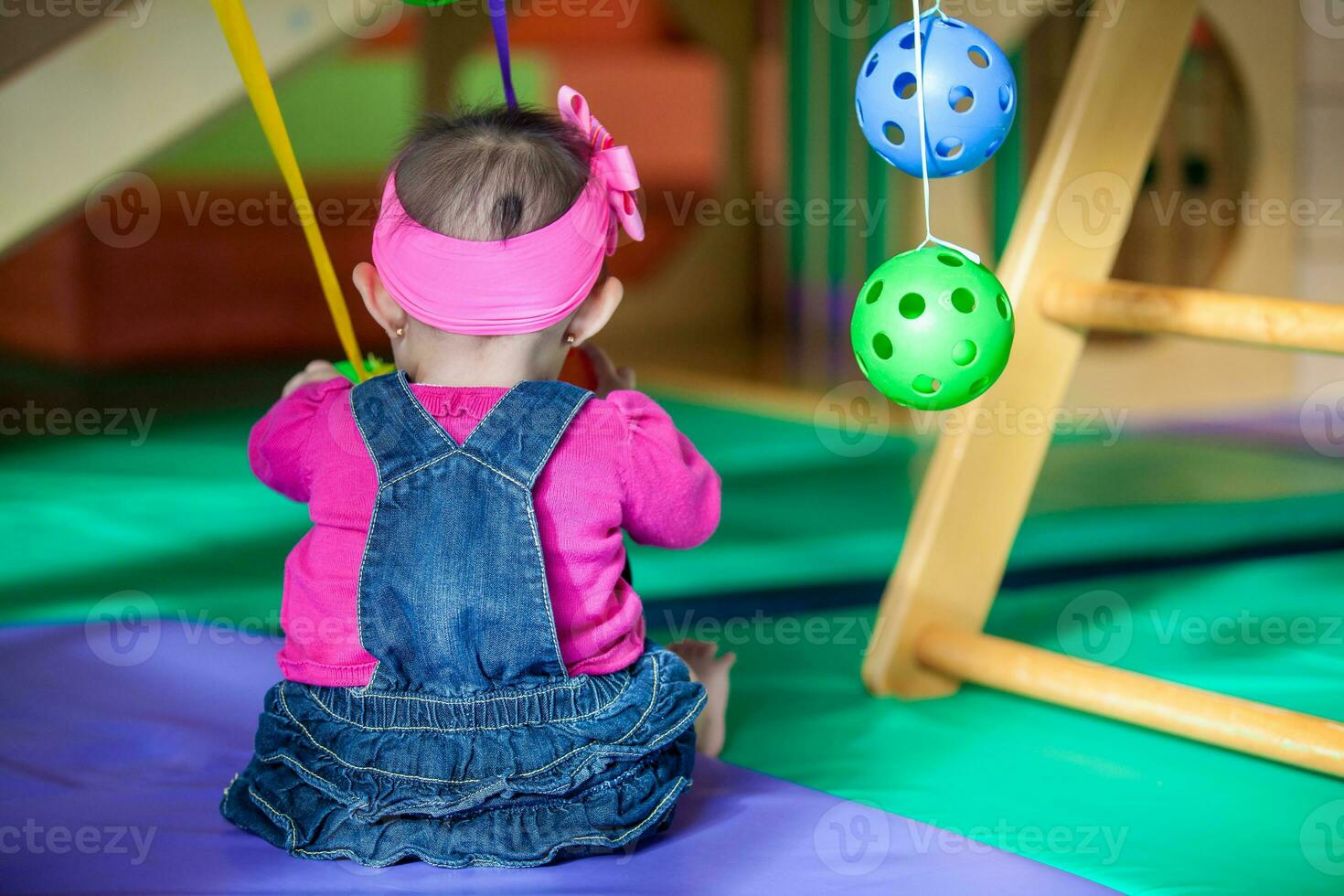 hermosa diez meses bebé niña jugando con vistoso pelotas. temprano estímulo para niños pequeños concepto. foto