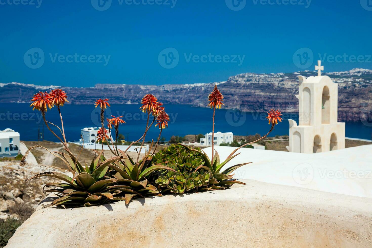 View of the Aegean sea and a traditonal bell tower from the ruins of the Castle of Akrotiri also known as Goulas or La Ponta, a former Venetian castle on the island of Santorini photo