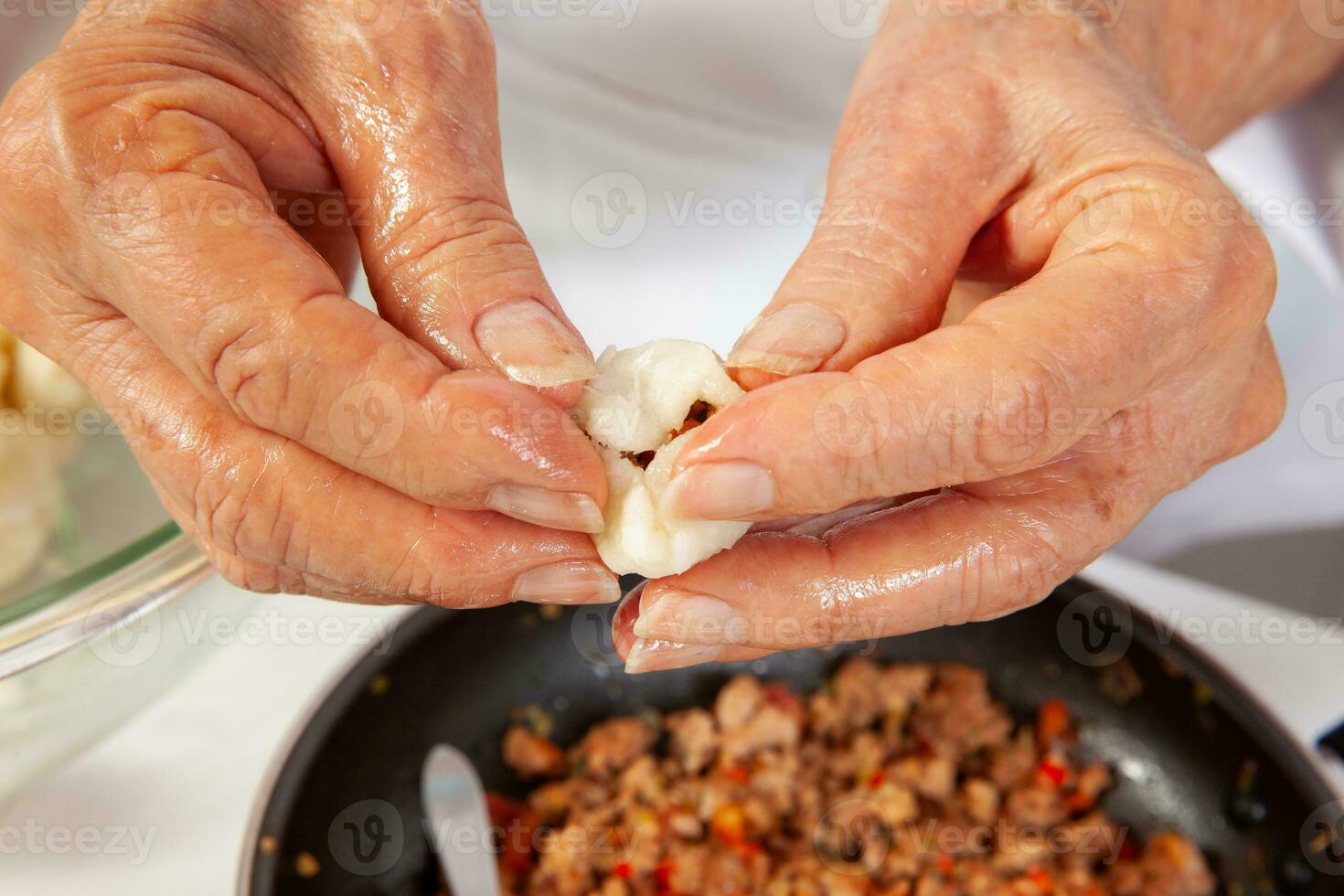 Preparation of a traditional Colombian fried  stuffed yucca dumplings called carimanolas photo