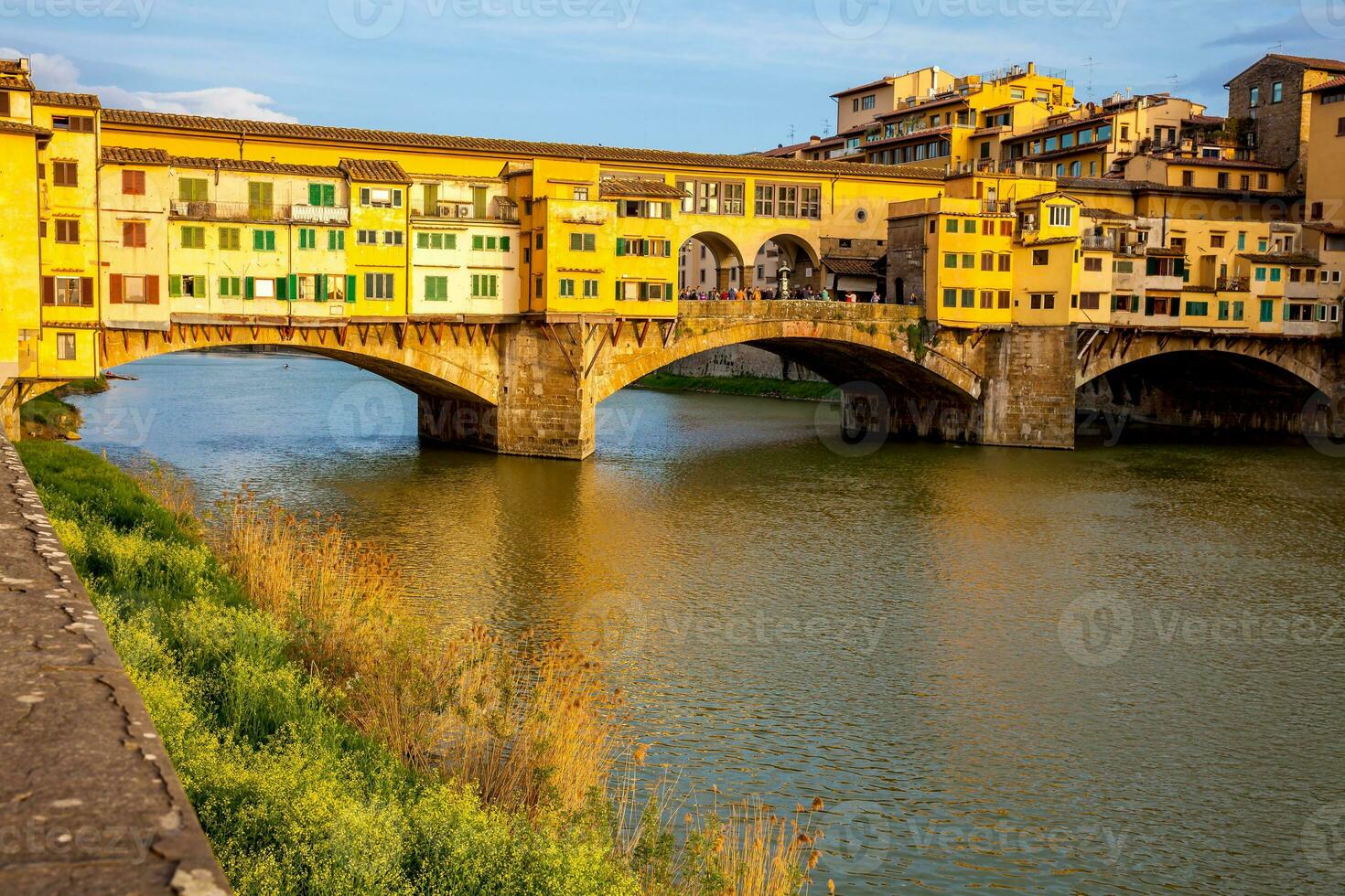 dorado hora a el ponte vecchio un medieval Roca enjuta cerrada segmentario arco puente terminado el arno río en florencia foto