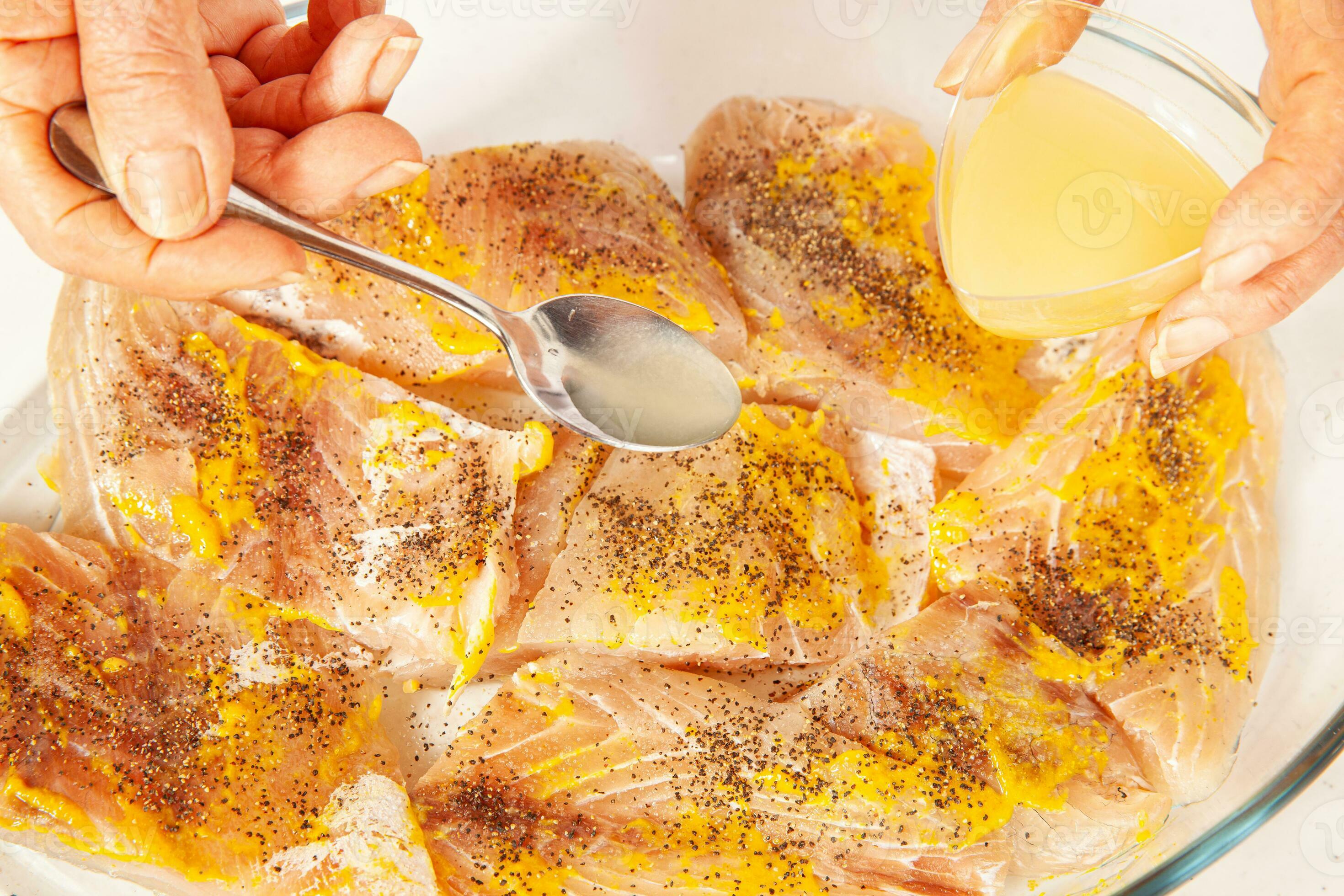 Fish marinade preparation steps. Adding lemon juice to the fish fillet pieces 26370121 Stock