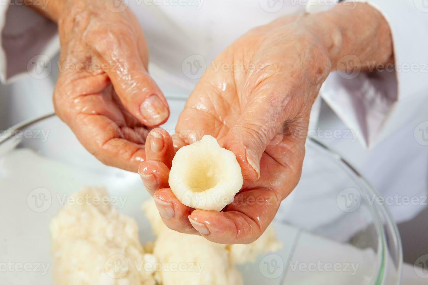 Preparation of a traditional Colombian fried  stuffed yucca dumplings called carimanolas photo