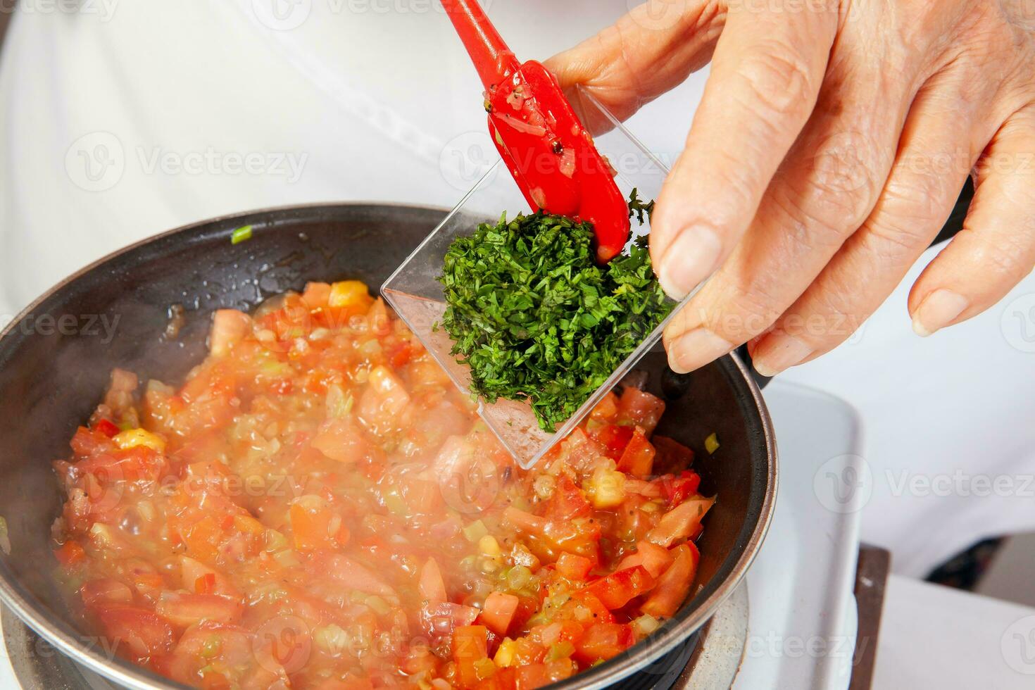 Preparation of the traditional Colombian hogao or criollo sauce made of onion, tomato, peppers and cilantro. Salsa criolla photo