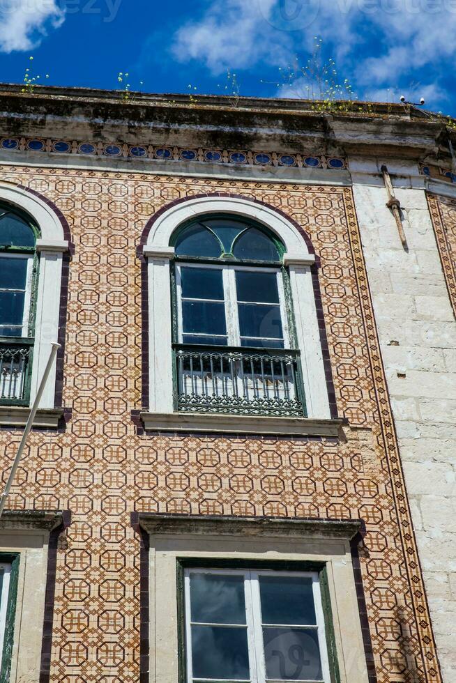 Traditional architecture of the facades covered with ceramic tiles called azulejos in the city of Lisbon in Portugal photo