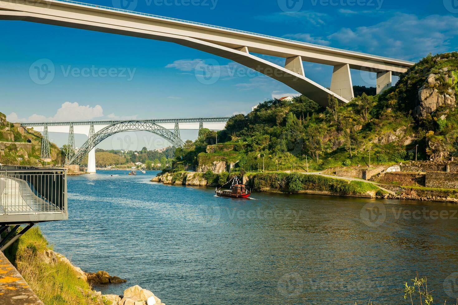 View of a vintage traditional boat sailing on the Douro River and some of the bridges that cross over it photo