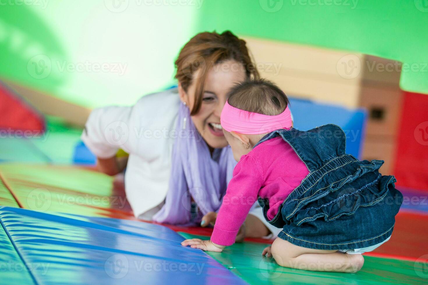 Beautiful ten months baby girl playing with her mom. Early stimulation for toddlers concept. photo