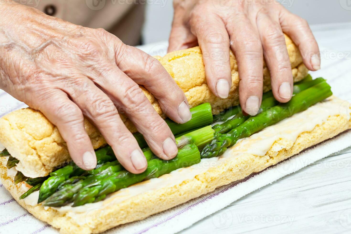 cerca arriba de un mayor mujer manos laminación un sólo horneado esponja pastel foto