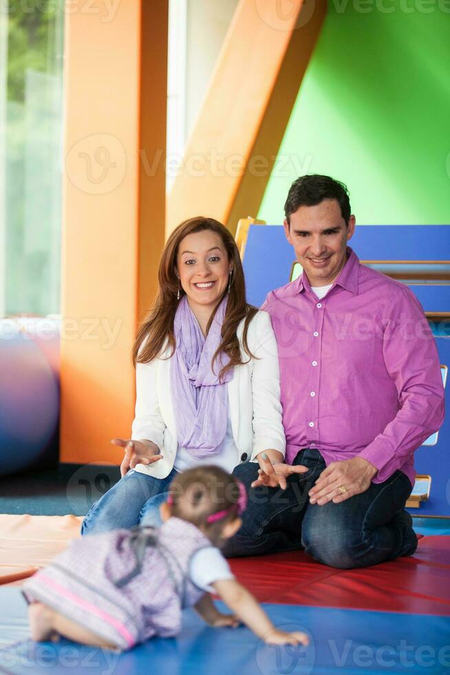 Young parents playing with their baby daughter. Early stimulation for toddlers concept. photo