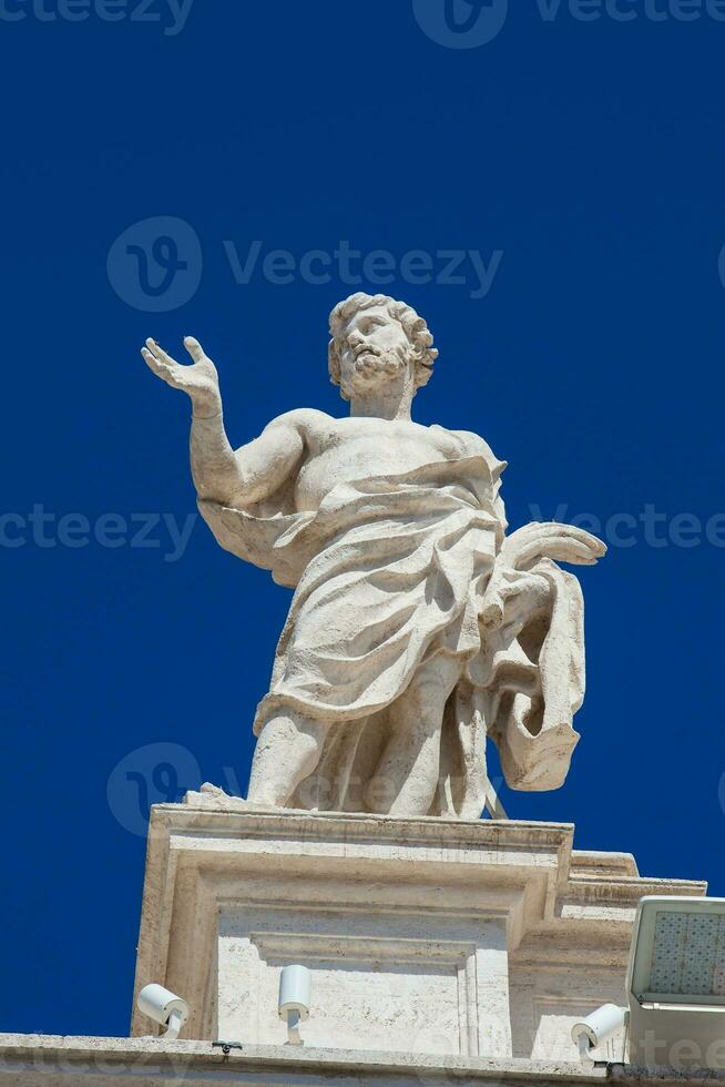 Detail of the statues of saints that crown the colonnades of St. Peter Square built on 1667 on the Vatican City photo