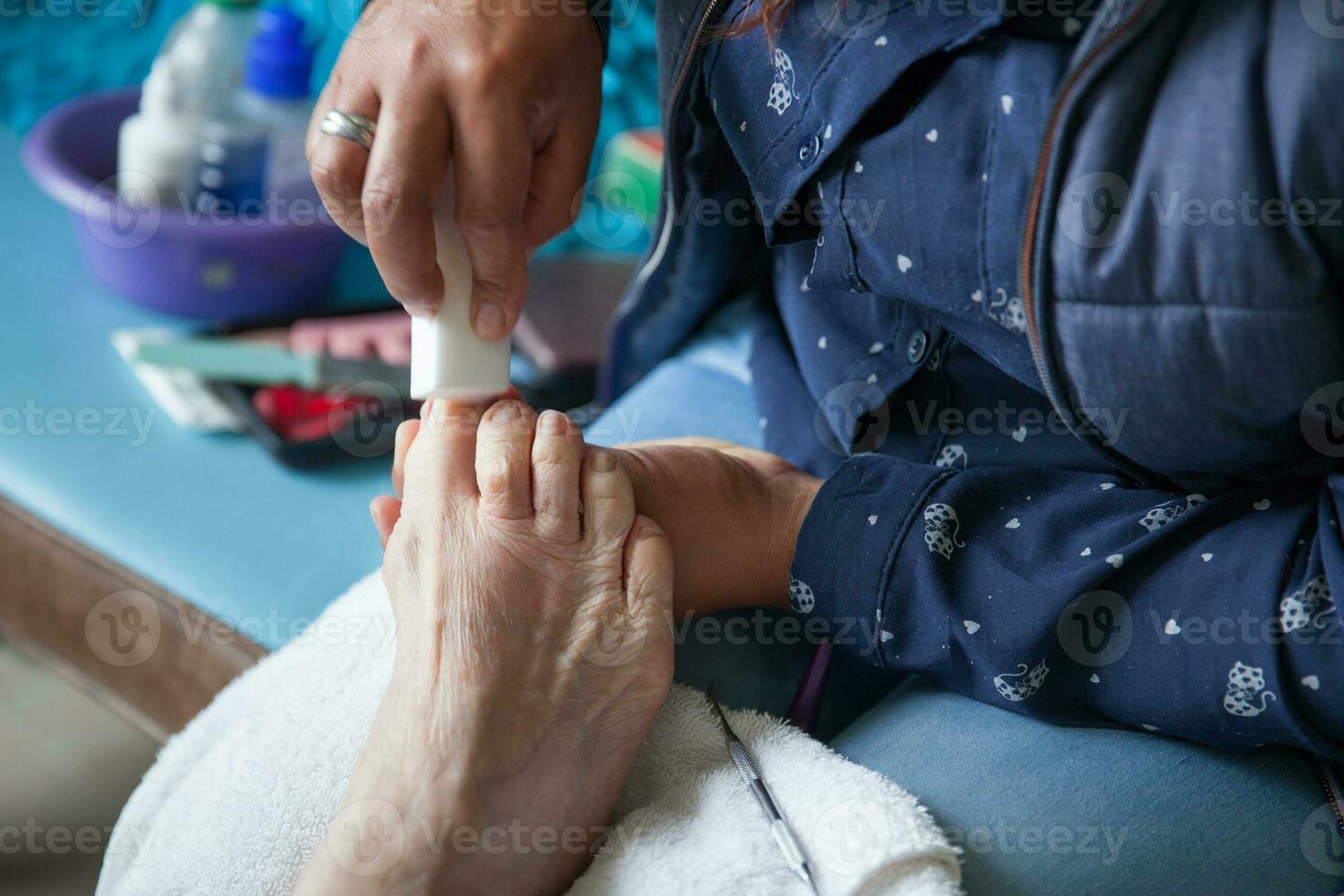 cerca arriba de un mayor mujer pie mientras consiguiendo un pedicure a hogar durante codicioso 19 pandemia foto