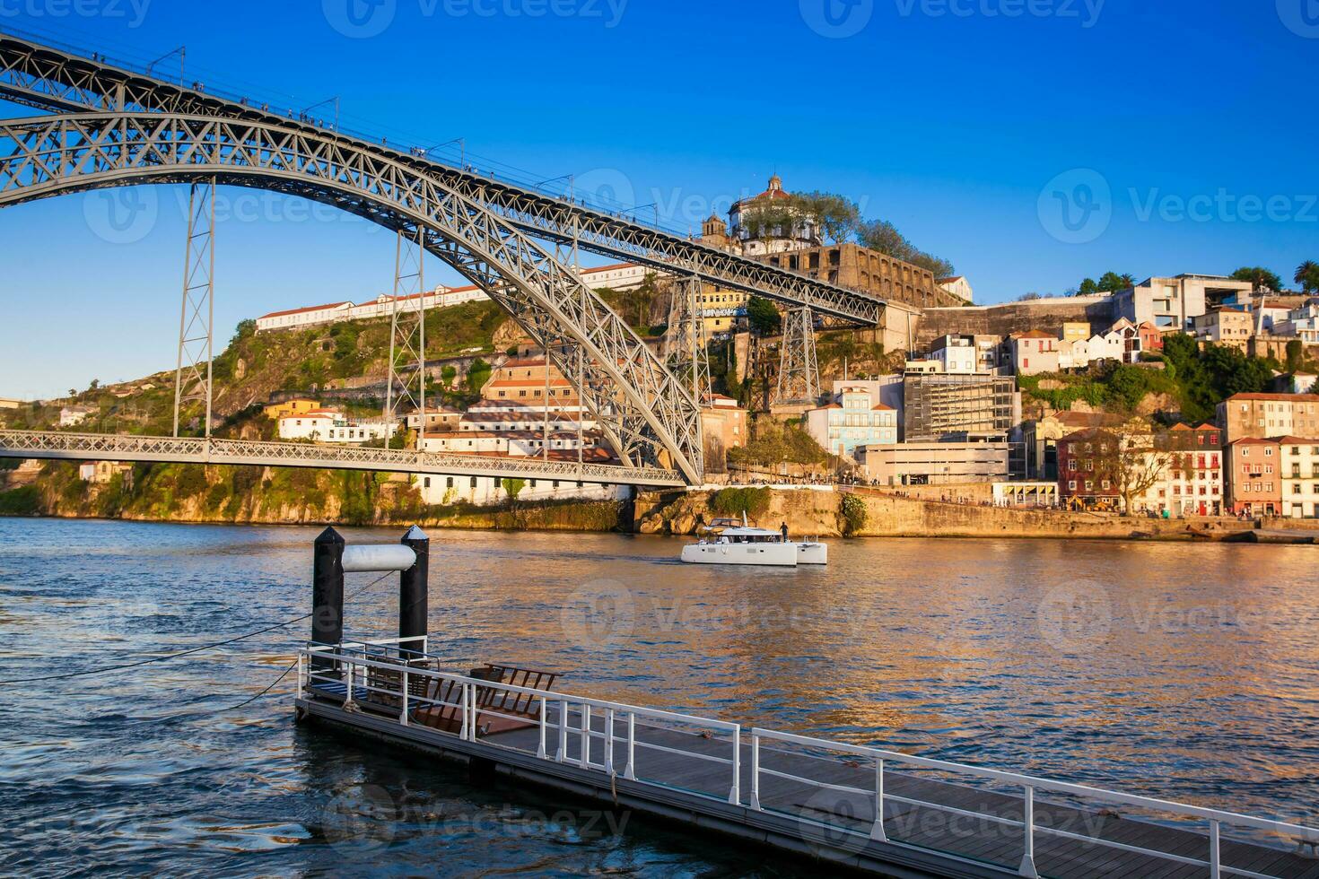 Modern boat and the Dom Luis I Bridge a metal arch bridge over the Douro River between the cities of Porto and Vila Nova de Gaia in Portugal inaugurated in 1886 photo