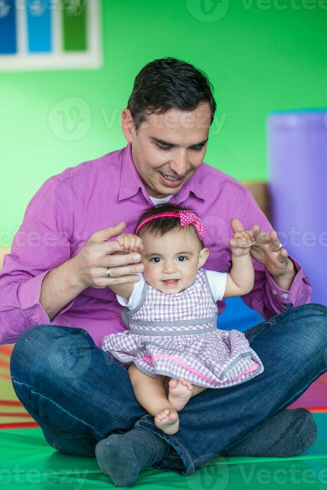 Beautiful ten months baby girl playing with her dad. Early stimulation for toddlers concept. photo