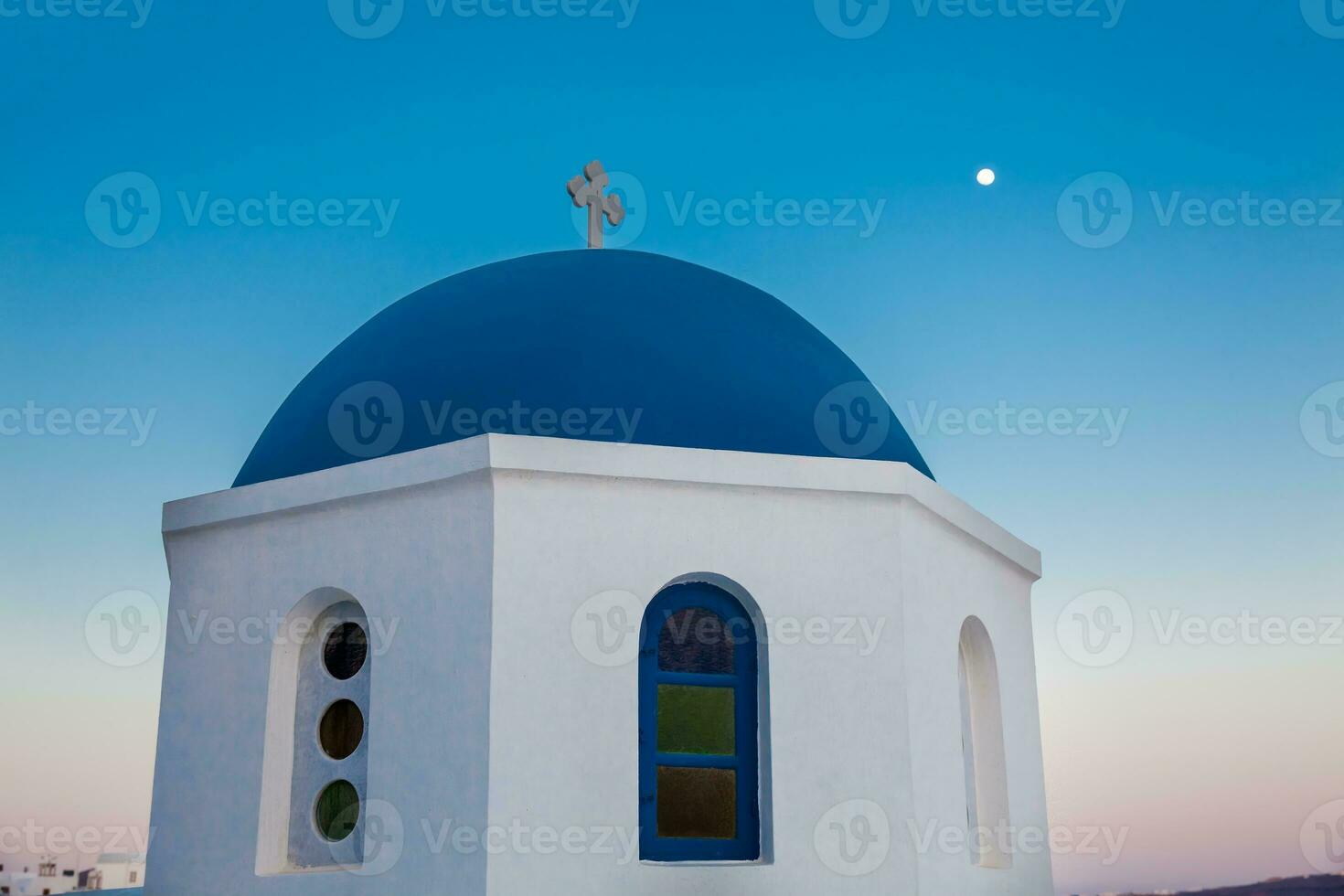 Traditional dome of the churches at Oia City and the moon in Santorini Island photo