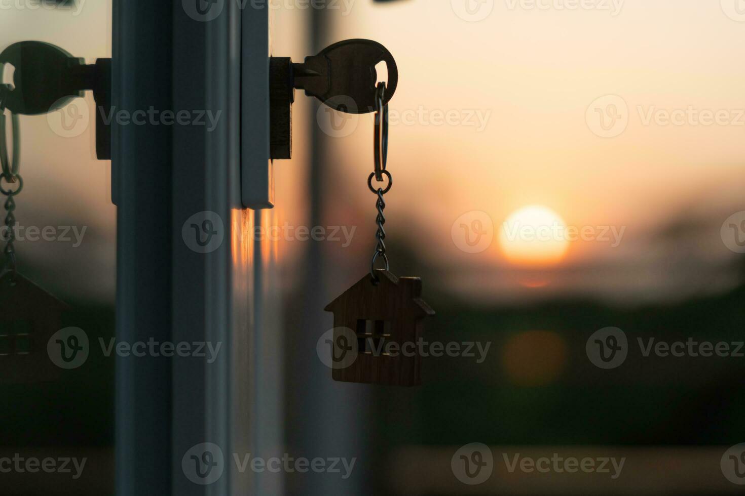 Landlord key for unlocking house is plugged into the door. Second hand house for rent and sale. keychain is blowing in the wind. mortgage for new home, buy, sell, renovate, investment, owner, estate photo