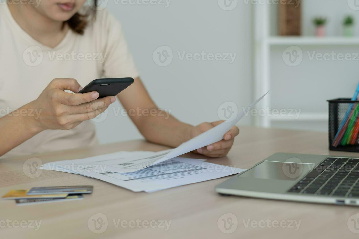 woman use phone scan barcode or QR codes to pay credit card bill after receiving document invoice. payment, receive, paying electricity, digital payments, technology, scanning, financial transactions photo