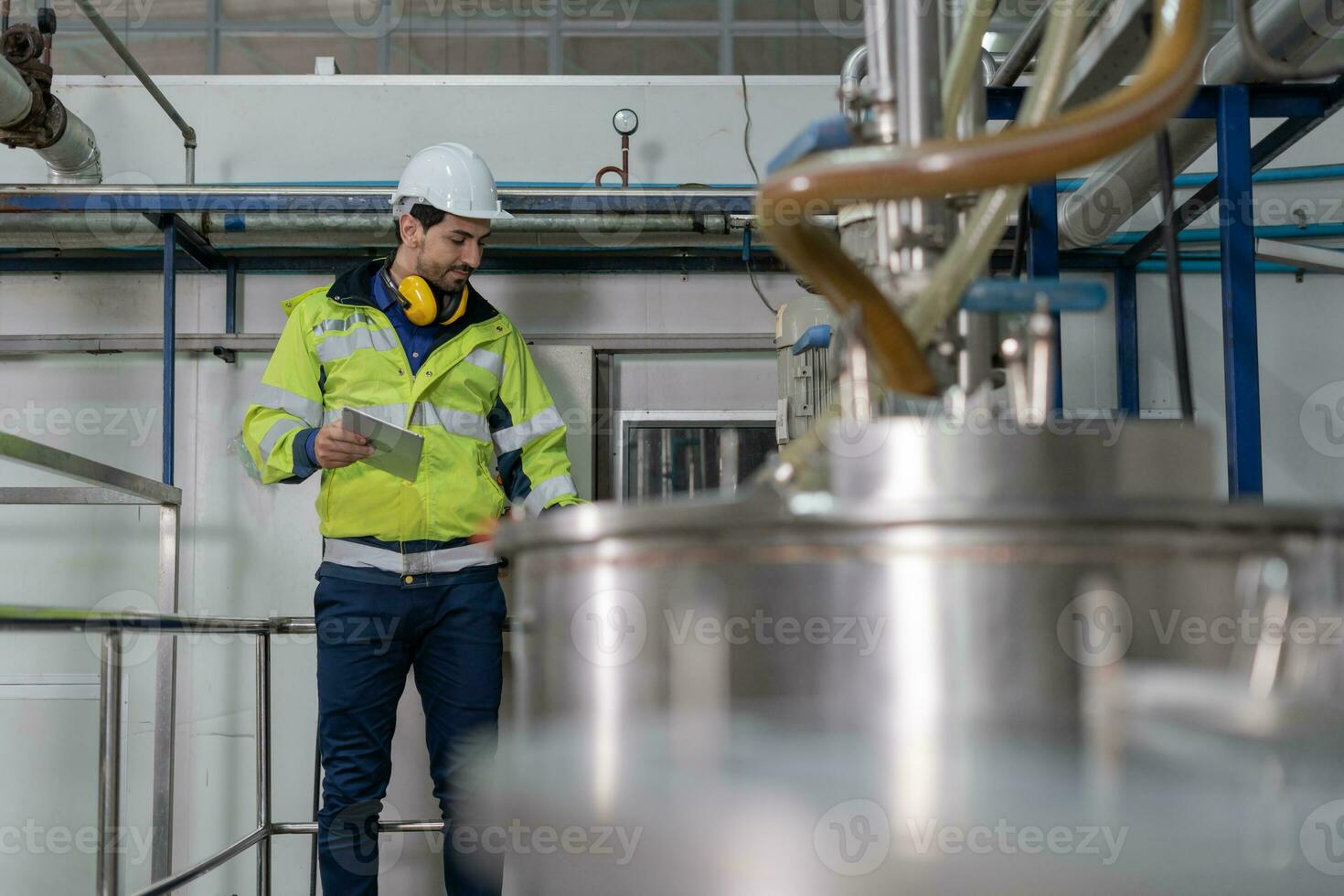 Engineers or factory managers wearing safety helmet inspect the machines in the production line. Utility inspector check machine and test the system to meet the standard. machine, maintenance. photo