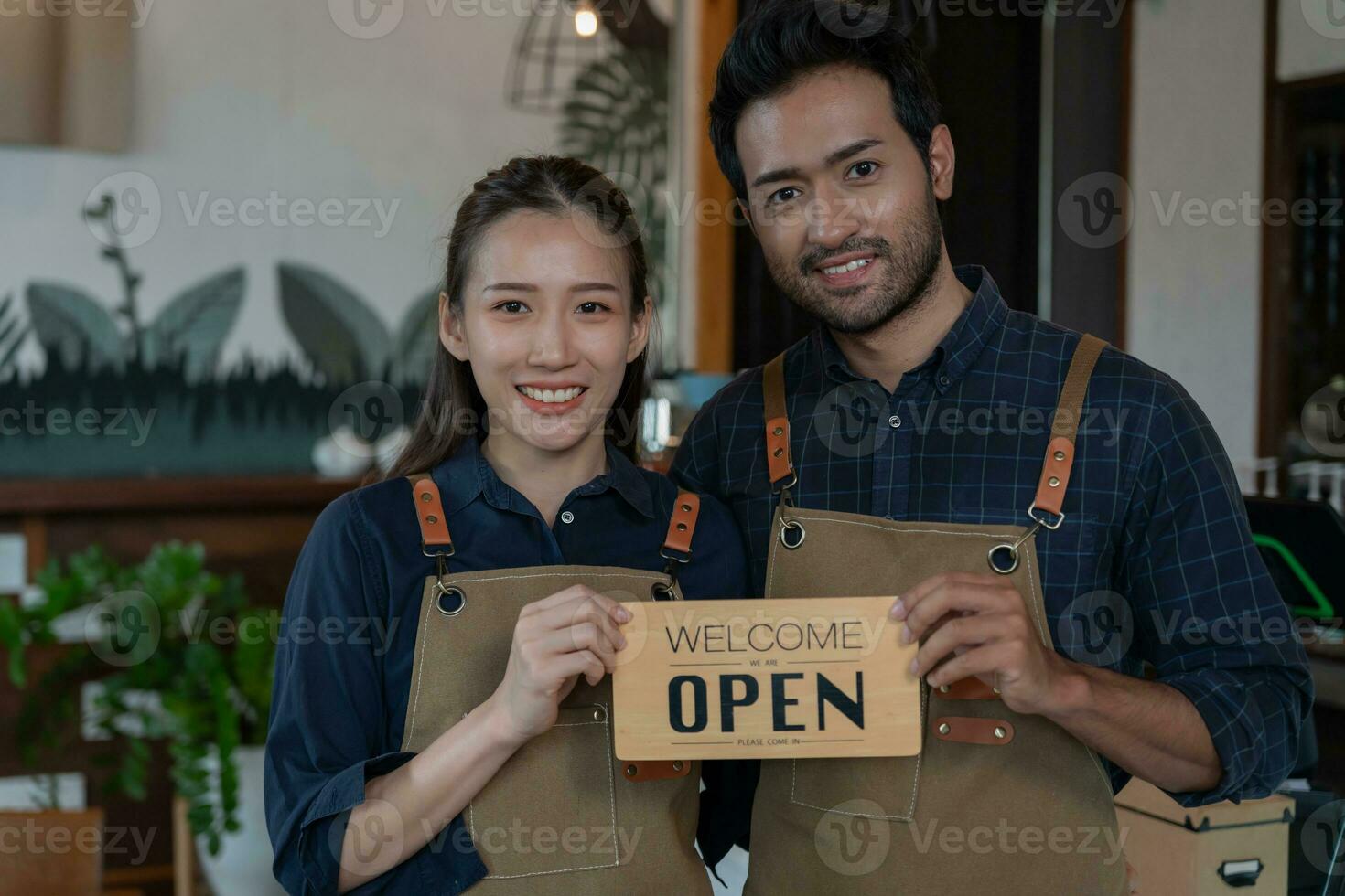 Asia couple owner show sign open on the first day of business. guarantees safety, cleanliness, open the coffee shop. open for New normal. Small business, welcome, restaurant, home made, family photo