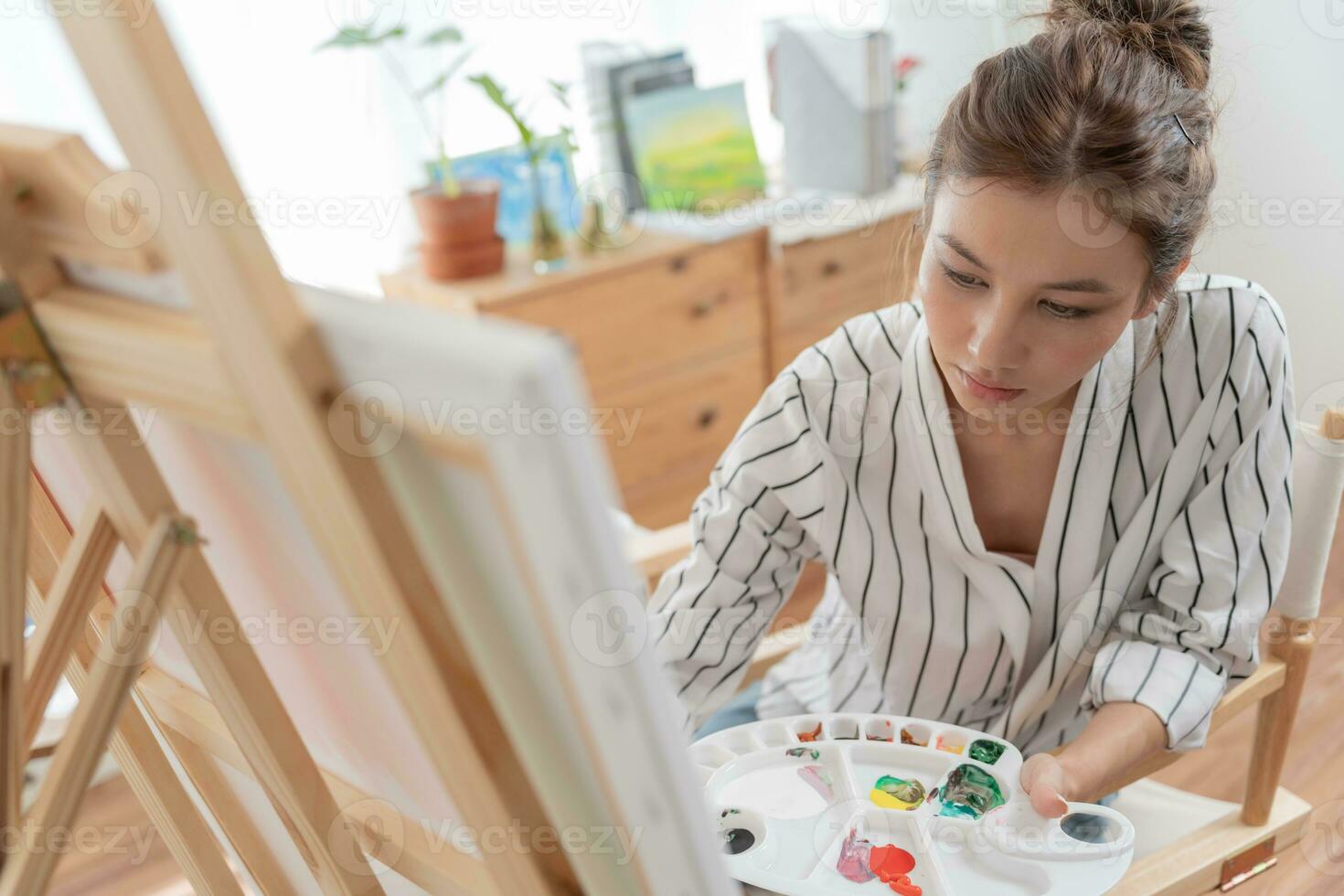 beautiful female hobbies about artist and use paintbrush in abstract art for create masterpiece. painter paint with watercolors or oil in studio house. enjoy painting as hobby, recreation photo
