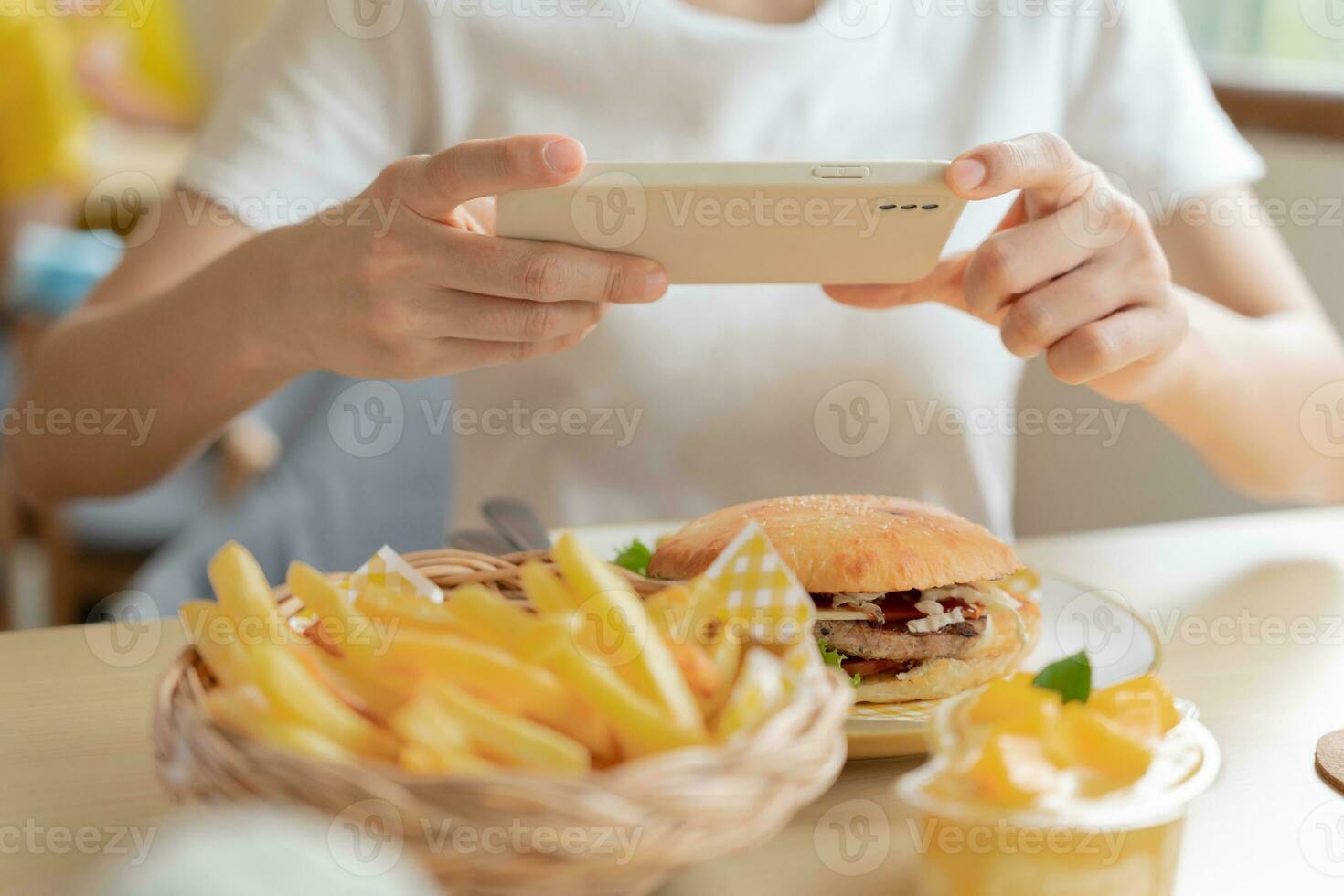 restaurant owner takes a picture of the food on the table with a smartphone to post on a website. Online food delivery, ordering service, influencer, review, social media, share, marketing, interest. photo