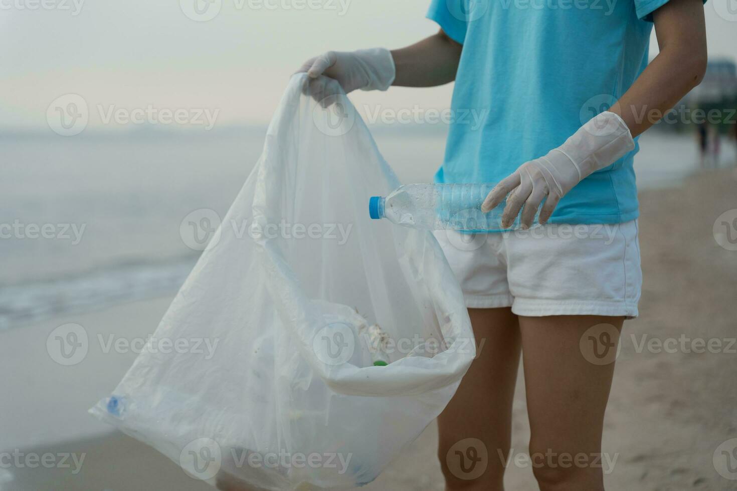Save water. Volunteer pick up trash garbage at the beach and plastic bottles are difficult decompose prevent harm aquatic life. Earth, Environment, Greening planet, reduce global warming, Save world photo