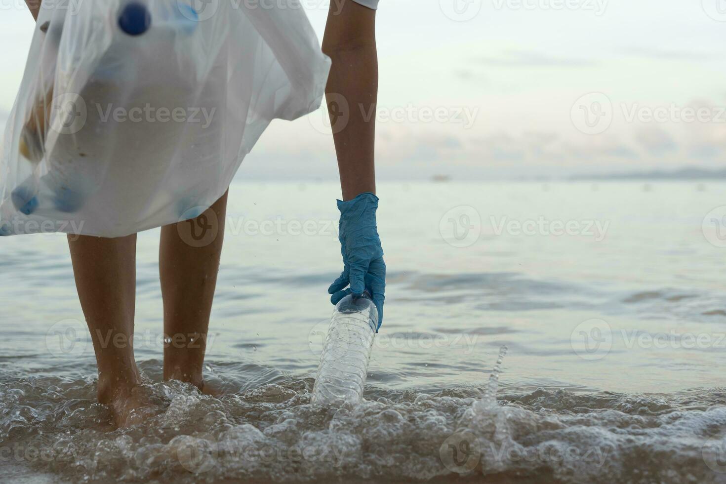 Save water. Volunteer pick up trash garbage at the beach and plastic bottles are difficult decompose prevent harm aquatic life. Earth, Environment, Greening planet, reduce global warming, Save world photo