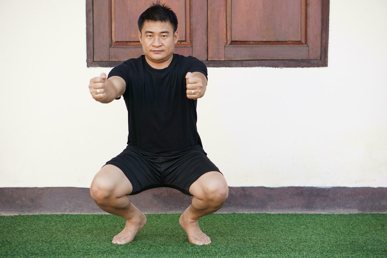 Asian man is doing yoga exercise at home. Concept, Health care, fitness, healthy lifestyle living . Healthy mind in a healthy body. photo