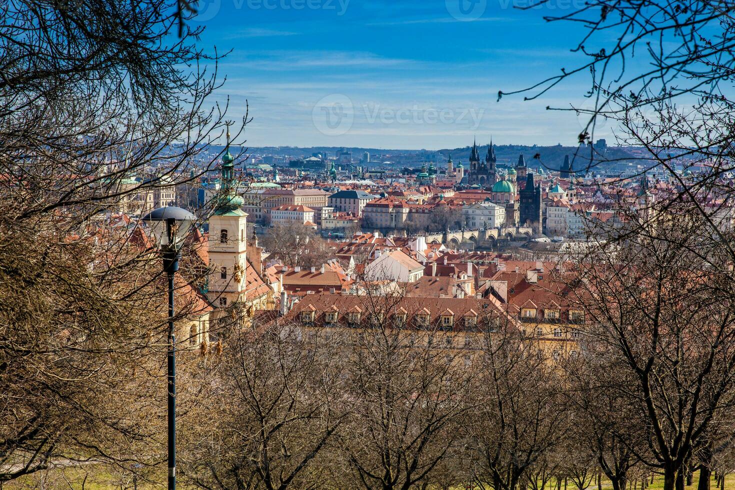 Prague city seen from the Petrin Gardens on a sunny day at the beginning of spring photo