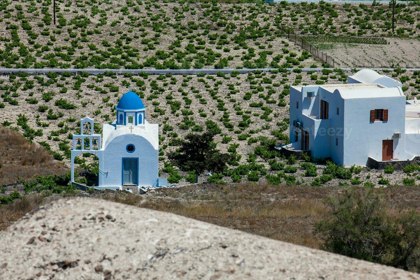 Vineyards and the Holy Trinity Church located in Akrotiri village on the Santorini Island photo