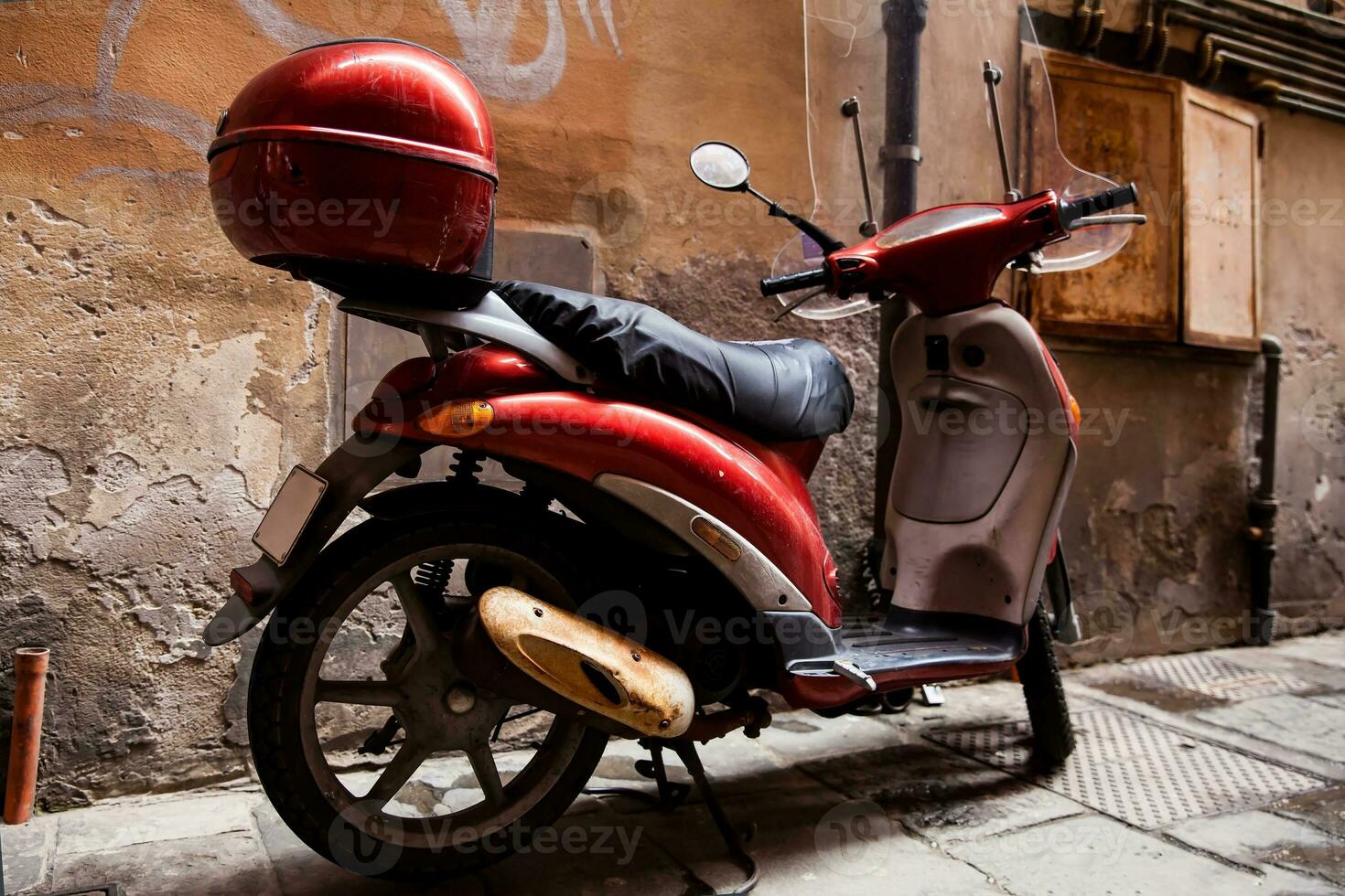 Red vintage scooter parked at Pisa city center photo